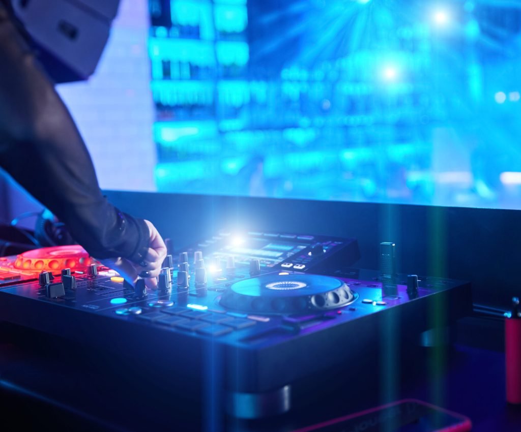 Dj girl playing music with turntables and sound mixer on stage in night club