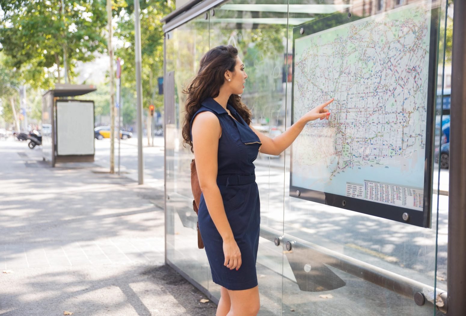 serious-young-woman-consulting-map-bus-station-min